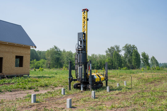 Diesel hammer drives concrete piles for a country house.