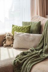 Obraz premium Cozy living room scene with plush pillows and a soft blanket on a sofa