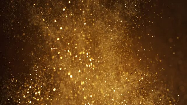 Abstract background of golden glitter particles floating in the air against a dark background