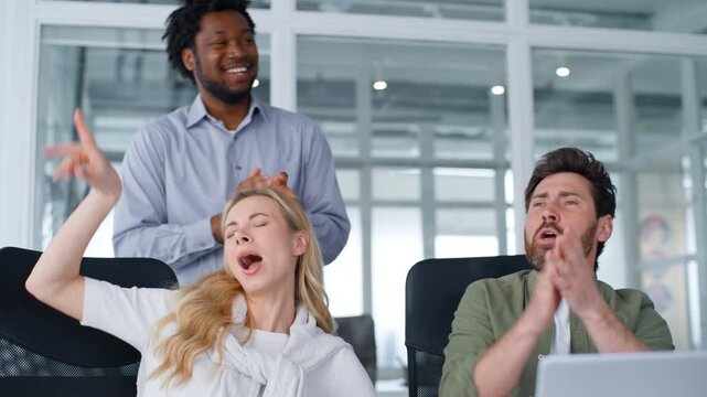 Funny business team happy yelling singing dancing giving high five at office multiracial three colleagues sing dance applauding cheering in working company men with woman rejoicing work laptop achieve