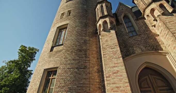 Architectural detail of Flatow Tower in Babelsberg Park, Potsdam, Germany, with a pointed window and cylindrical brick tower.