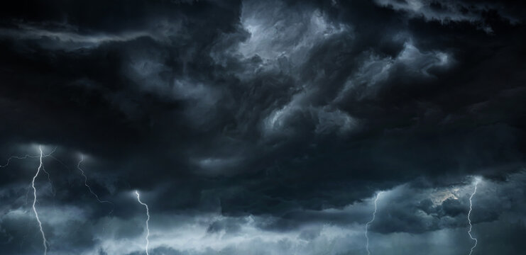 Thunderous dark sky with black clouds and flashing lightning. Panoramic view. Concept on the theme of weather, natural disasters, storms, typhoons, tornadoes, thunderstorms, lightning, lightning.