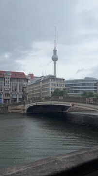 Raining in Berlin, moody and cloudy weather at the city center. TV Tower, Spree river and bridge, facades of old buildings. Perfect Berlin cityscape with typical mood and weather conditions