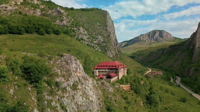 Traditional architecture standing in a vibrant mountain landscape with towering cliffs