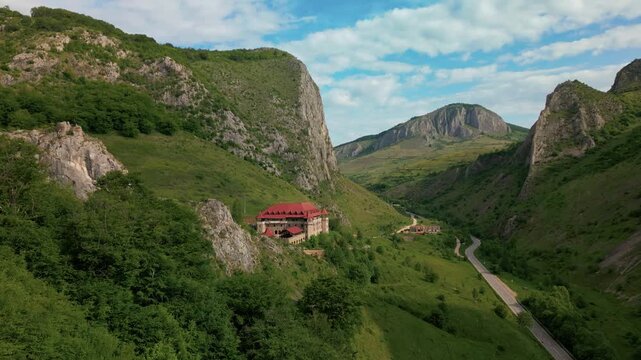 Traditional architecture standing in a vibrant mountain landscape with towering cliffs