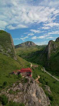Aerial view of historic castle showcasing traditional architecture nestled in a lush green mountain valley