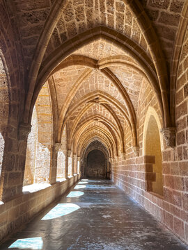 Gothic stone corridor with pointed arches