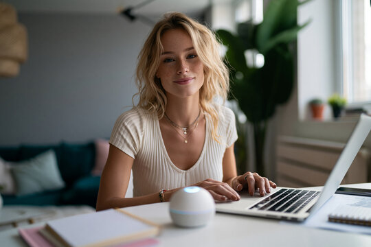 Young Woman Working on Laptop with Smart Assistant at Home