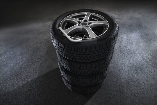 Car tires with a great profile on asphalt isolated on black background. Set of summer or winter tyres.