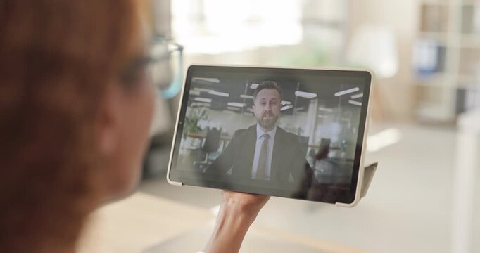 Woman and businessman join remote online videocall meeting. A male colleague appears on screen in a bright office. It enables digital communication. Modern virtual meeting communication concept.