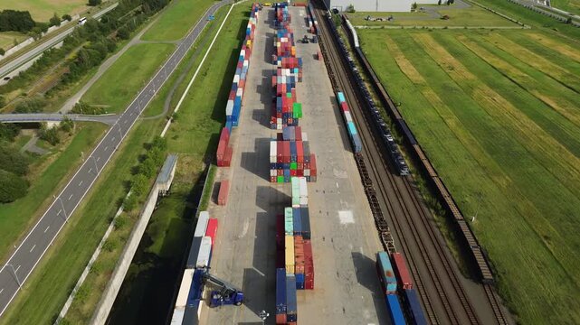 Top view of colorful cargo, container cargo train and truck for freight transport in the railway station, logistics and international trade on the railroad. Heavy industry. Industrial conceptual scene