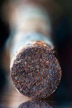 Close up view of the cross section of a rusted steel rod in an industrial setting, corrosion, raw metal texture steel