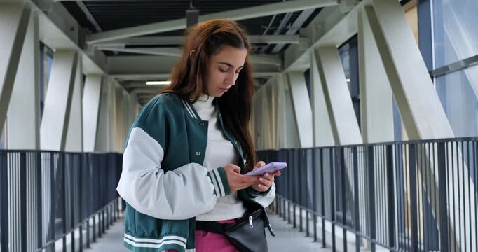 Young learner responds calmly. Attentive pupil wearing vibrant attire acknowledges message. Brightly dressed student with focused expression interacts through message on enclosed bridge area