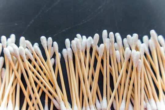 Cotton swabs arranged neatly on a flat surface in a close view showing their uniform shape and texture