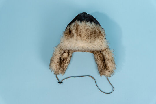 Fur-lined winter hat on light blue background