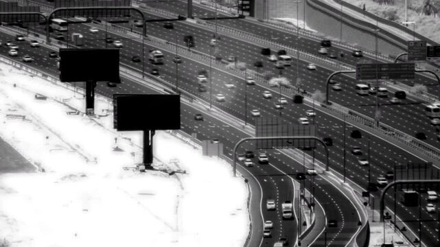 Infrared timelapse of heavy vehicle traffic moving along a multi lane highway with large blank billboards in the foreground