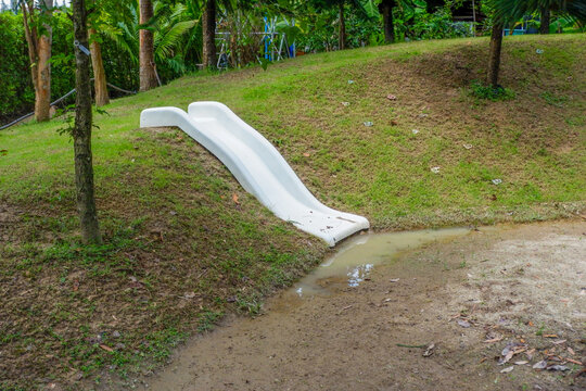 Playground slide with green grass in morning,Empty Outdoor playground,Children Play area in park or garden,Play yard,equipment,School yard, concept.
