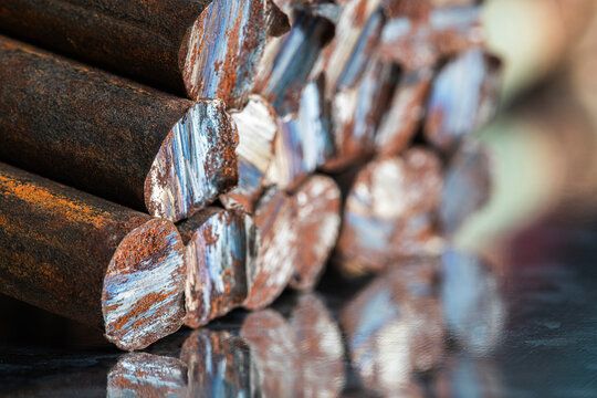 Stack of rusted steel rods with unevenly cut ends, raw metal structure, corrosion, industrial texture, and character of steelmaking and metallurgical products