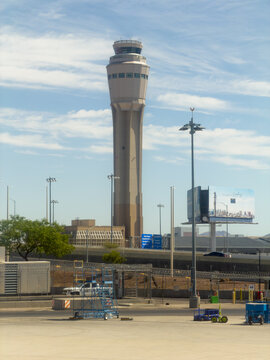 LAS VEGAS, NV, APR 28, 2026: Close-up of a modern airport control tower with wayfinding signs, fencing, and ground equipment below