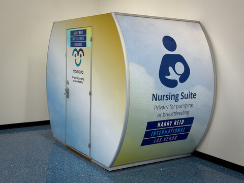 LAS VEGAS, NV, APR 28, 2026: Pod-shaped Mamava nursing suite branded for Harry Reid International Airport sits in a corner against beige walls and speckled blue flooring