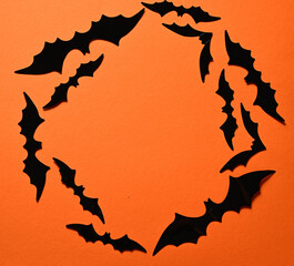 Obraz premium halloween decoration with black paper bats arranged in a circle on orange background