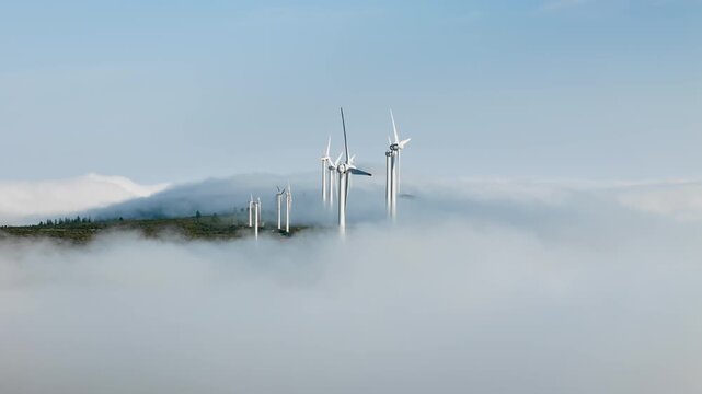 Wind turbines above cloud layer on mountainous landscape, Madeira Island. Renewable electricity generation at elevation