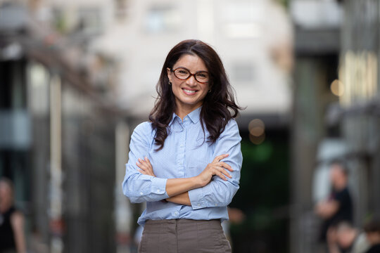 Confident business woman smiling in city street