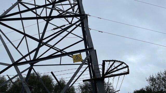 Electricity Pylon Base with Danger of Death Warning Sign and Barbed Wire Fence