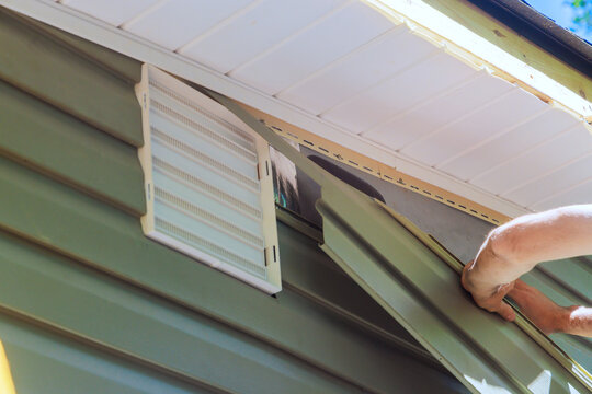 Homeowner installing new siding on house under construction