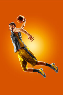 Basketball. Professional basketball player on an orange background. Basketball in action. Basketball theme. Sport.