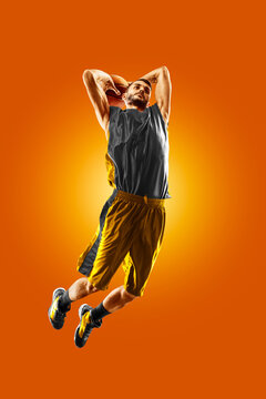 Basketball. Professional basketball player on an orange background. Basketball in action. Basketball theme. Sport.