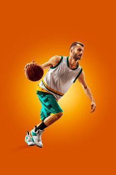 Basketball. Professional basketball player on an orange background. Basketball in action. Basketball theme. Sport.