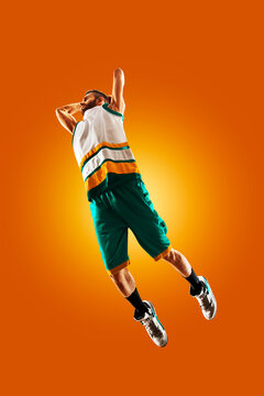 Basketball. Professional basketball player on an orange background. Basketball in action. Basketball theme. Sport.