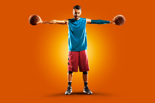 Basketball. Professional basketball player on an orange background. Basketball in action. Basketball theme. Sport.