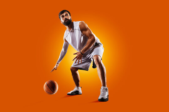 Basketball. Professional basketball player on an orange background. Basketball in action. Basketball theme. Sport.