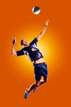 Volleyball. Professional volleyball player isolated against an orange background. Volleyball in action. Volleyball concept. Sport.