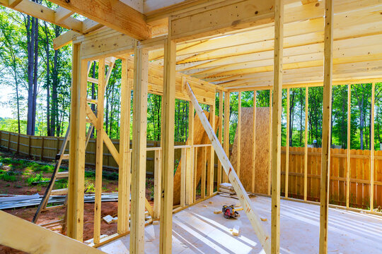 Construction site wooden framework in progress near wooded area