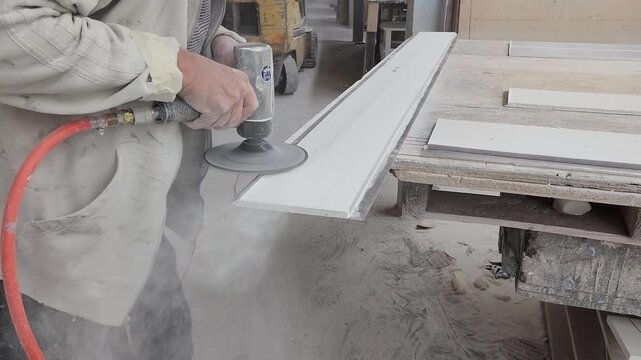 Industrial Worker Sanding Material With Pneumatic Tool in Manufacturing Workshop