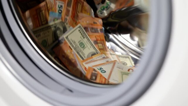 Money laundering euros and dollars. Large pile of euro and dollar banknotes spinning inside a washing machine drum, a conceptual representation of financial crime, money laundering, and corruption