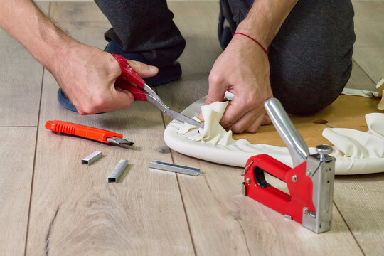 Indoor installation work: staple gun, fabric, wooden base, wooden floor 