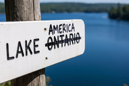 Lake Ontario wooden sign with Ontario crossed out and replaced with America following Presidents executive order renaming the body of water to Lake America amid US Canada trade dispute