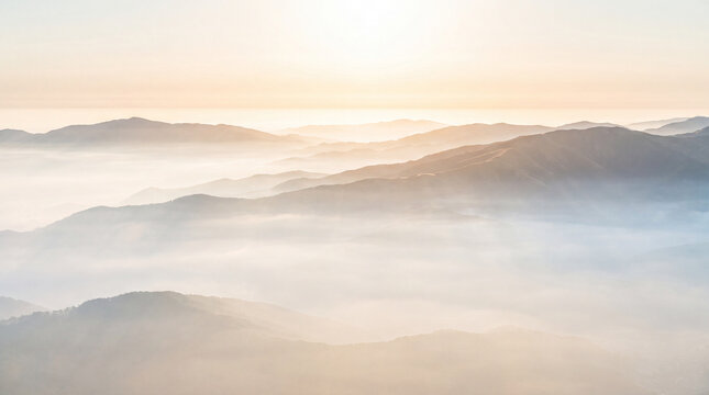 Panoramic view of misty mountain ranges at sunrise