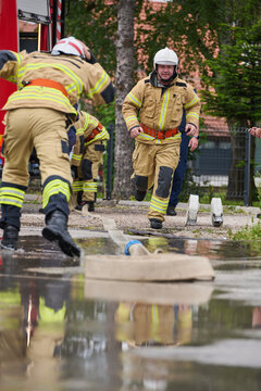 Firefighters Running to Scene During Training Exercise With Fire Hose and Equipment