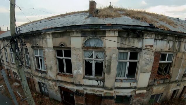 Ultra-high-definition 4K wide-angle drone footage capturing a creepy abandoned building with shattered windows and tattered curtains evoking post-apocalyptic urban decay and Chernobyl-style