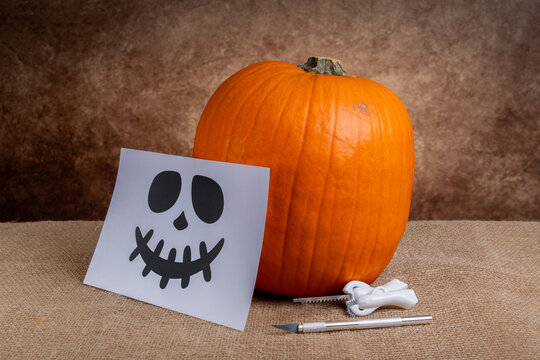 Halloween pumpkin carving kit with skull face stencil on burlap
