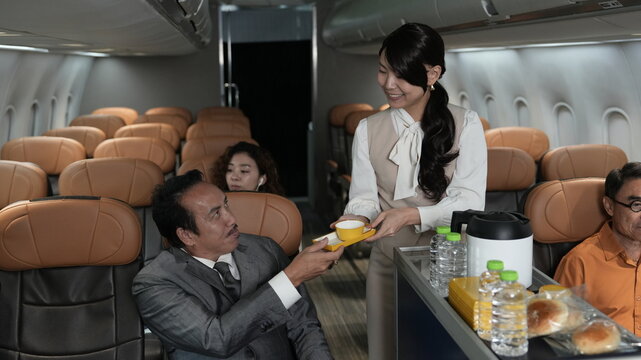 Flight attendants are serving passengers and providing in-flight safety instructions.
