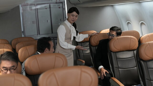 Flight attendants are serving passengers and providing in-flight safety instructions.