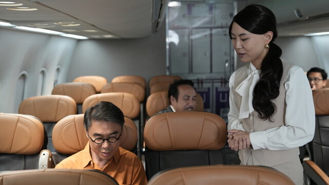 Flight attendants are serving passengers and providing in-flight safety instructions.