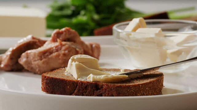 Young woman spreading nut butter on rye black bread toast in kitchen, closeup