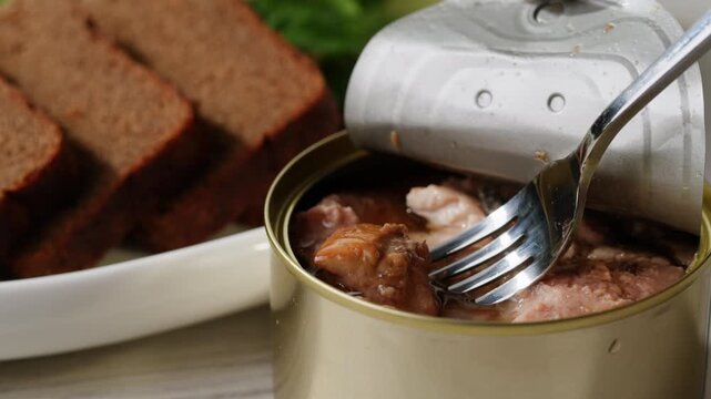 Cod liver superfood can, omega 3 Smoked cod liver in oil in open tin can with fresh greens on wooden table. Seafoods delicacy
